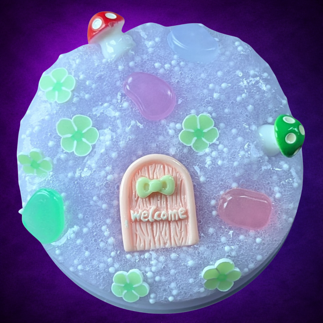 Overhead view of Into the Sídhe purple slime and white foam beads with a pink door and woodland decorations.