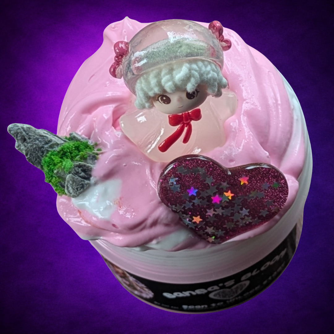 Overhead view of Banba’s Bloom pink and white butter swirl with a figure, stone and glitter heart.